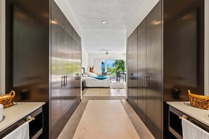A hallway leading to a bedroom with a bed, a view of the outdoors, and a ceiling fan. - El Tigre De Luxe, Spacious PH Terrace & Golf View (Nuevo Vallarta)
