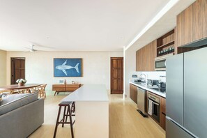 Eine moderne Küche mit Holzausbau, Edelstahlgeräten und einem Essbereich mit großem Tisch und Stühlen.