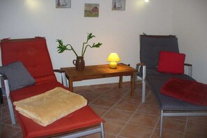 Ein Zimmer mit zwei Einzelbetten, einem kleinen Tisch mit einer Lampe und einem Blumentopf.