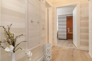 Ein Hotelzimmer mit Holzboden, einer weißen Tür und Blick in ein weiteres Zimmer.