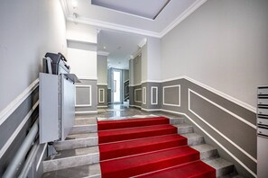 Una ampla escala amb vestíbul revestit de catifes vermelles.