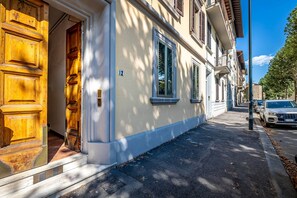 A building with a large wooden door, a number '12' sign, and a row of windows. - Aleardi (Florence)