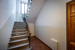 A staircase with a wooden handrail leading to a landing. - Aleardi (Florence)