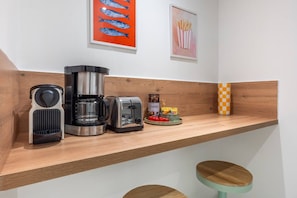 A kitchen counter with a coffee maker, toaster, and a jar of coffee creamer. - 20 min from Paris - 2 parking spaces - 6 beds - 3 bedrooms - 2 bathrooms (Argenteuil)