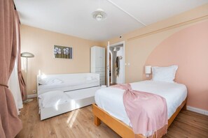 A bedroom with a bed, a sofa, a wardrobe, and a painting on the wall. - 20 min from Paris - 2 parking spaces - 6 beds - 3 bedrooms - 2 bathrooms (Argenteuil)