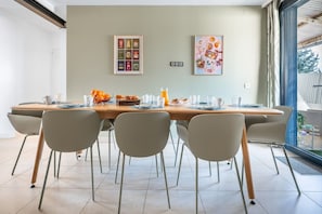 A dining area with a long table, chairs, and breakfast items. - Spacious Apartment—5 Bedrooms—Accommodates 10 Guests—20 Minutes from Paris—2 Parking Spaces (Argenteuil)