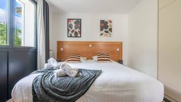 Une chambre d’hôtel avec un grand lit, deux oreillers, une couverture et une tête de lit.