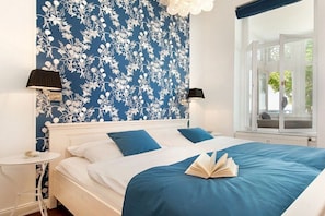 A bedroom with a bed, two bedside tables, and a window with a view. - Beach jewel - Villa Agnes (Binz)