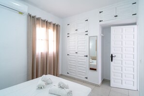 A hotel room with a bed, a mirror, and two white doors. - Holiday Home With sea View, Nerja (Nerja)