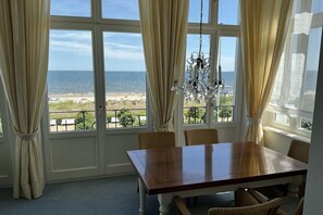 Ein Essbereich mit Blick auf den Strand und den Ozean durch große Fenster.