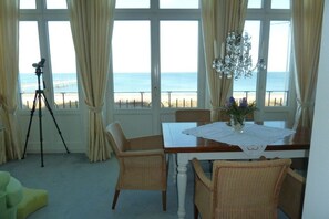 A dining area with a table, chairs, and a view of the beach. - (No. 8) in Villa Fortuna (Bansin)