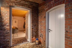 A brick exterior with a white door and a small step leading to a room. - Lokelk Hüs (Happy House) (Süderende \/ Föhr)