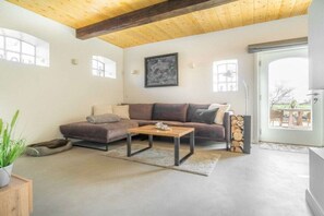 A modern living room with a sectional sofa, a coffee table, and a fireplace. - Lokelk Hüs (Happy House) (Süderende \/ Föhr)