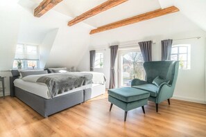 A bedroom with a bed, a chair, and a window. - Lokelk Hüs (Happy House) (Süderende \/ Föhr)