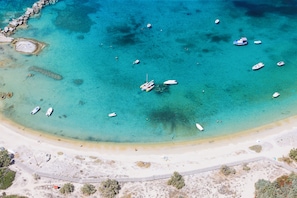 Una playa con aguas turquesas cristalinas, varios barcos y una orilla arenosa.