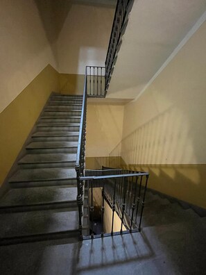 A staircase with metal railings and a handrail, leading to an upper floor. - San Rocco Apartment in Verbania (Verbania)