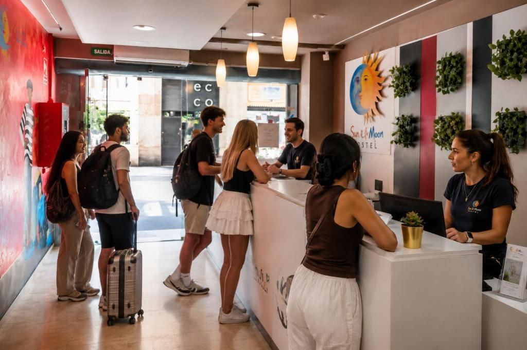 Un área de recepción con mostrador, un letrero que indica 'SALIDA' y una pared con diseño de sol y luna.