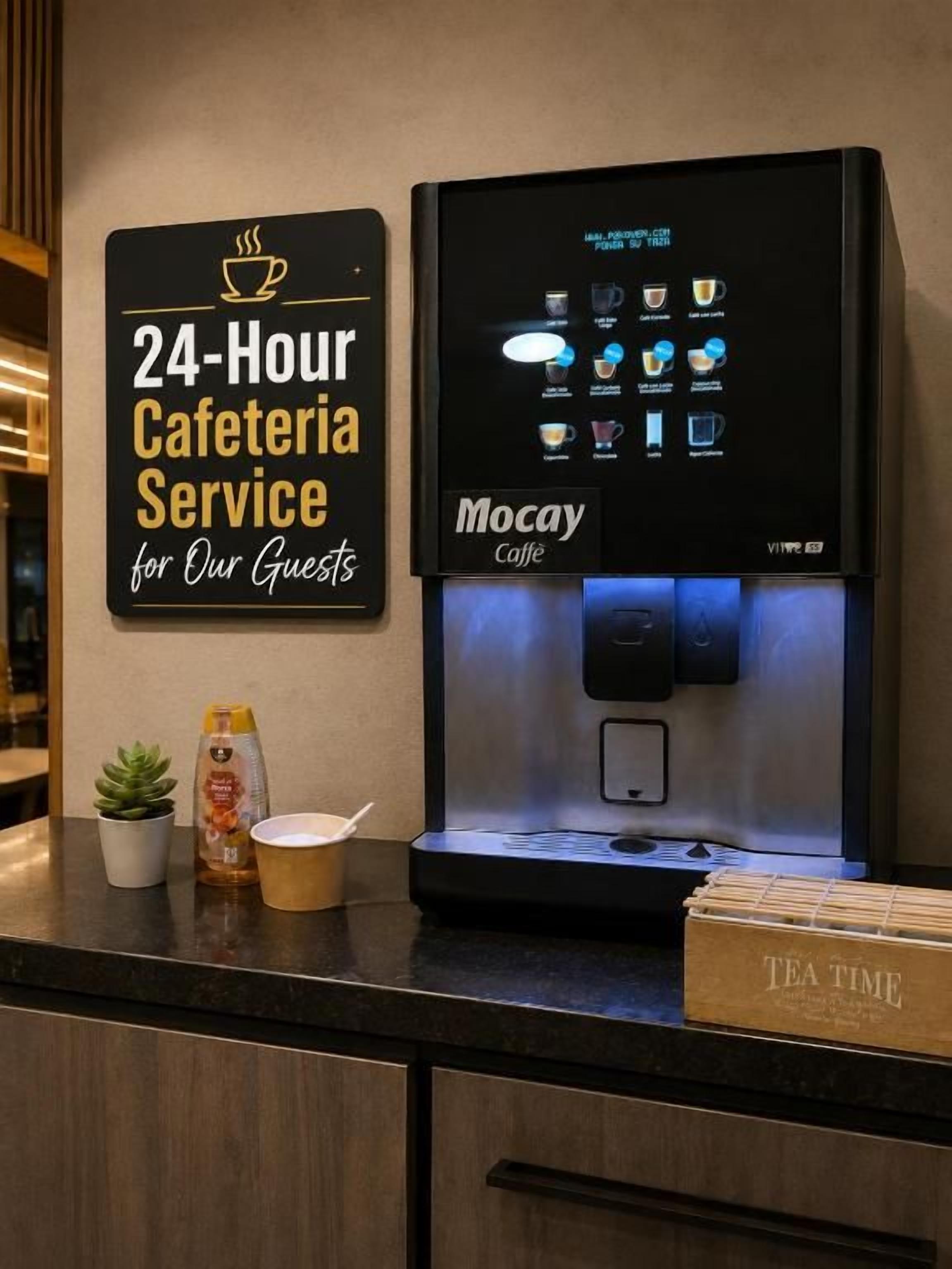 A 24-hour cafeteria service sign and a coffee machine with various drink options.