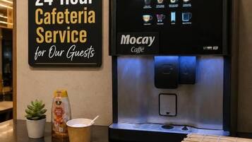 A 24-hour cafeteria service sign and a coffee machine with various drink options.