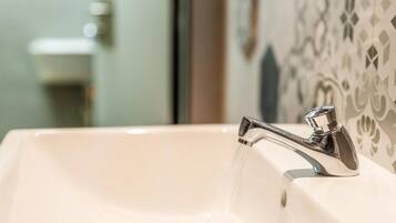 Un lavabo de baño con grifo cromado y agua corriendo.