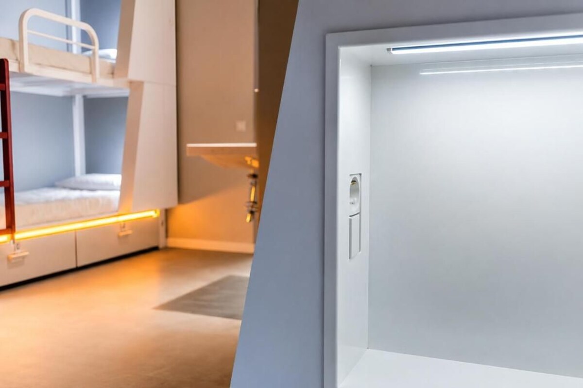 Un lit superposé avec une échelle, une porte avec une poignée et une bande lumineuse le long du mur.