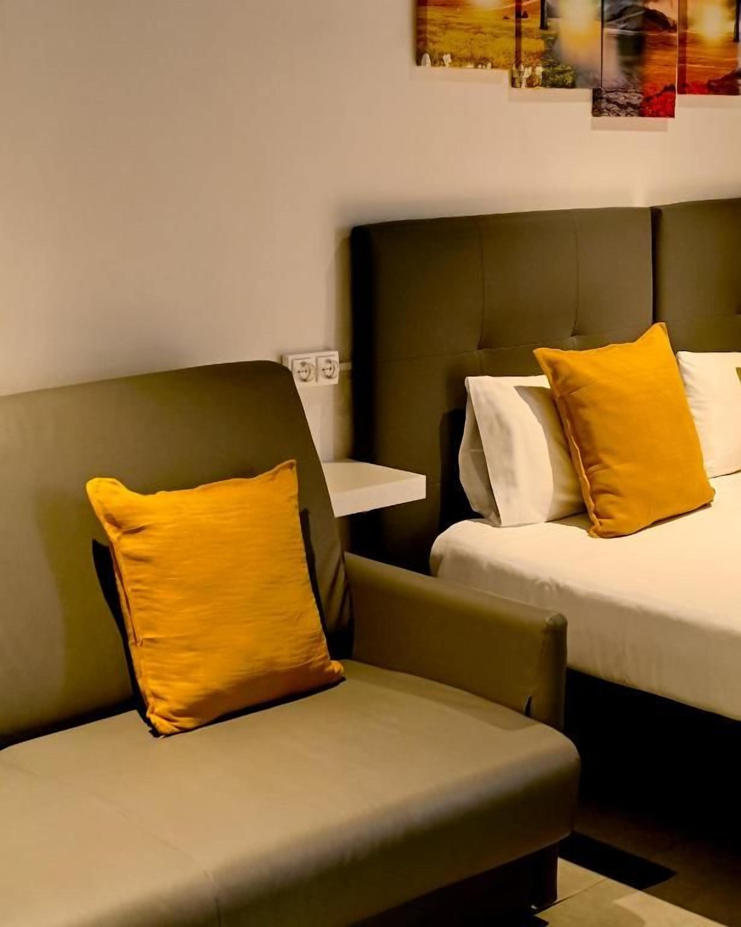 Una habitación de hotel con una cama, un sofá y una pequeña mesa.