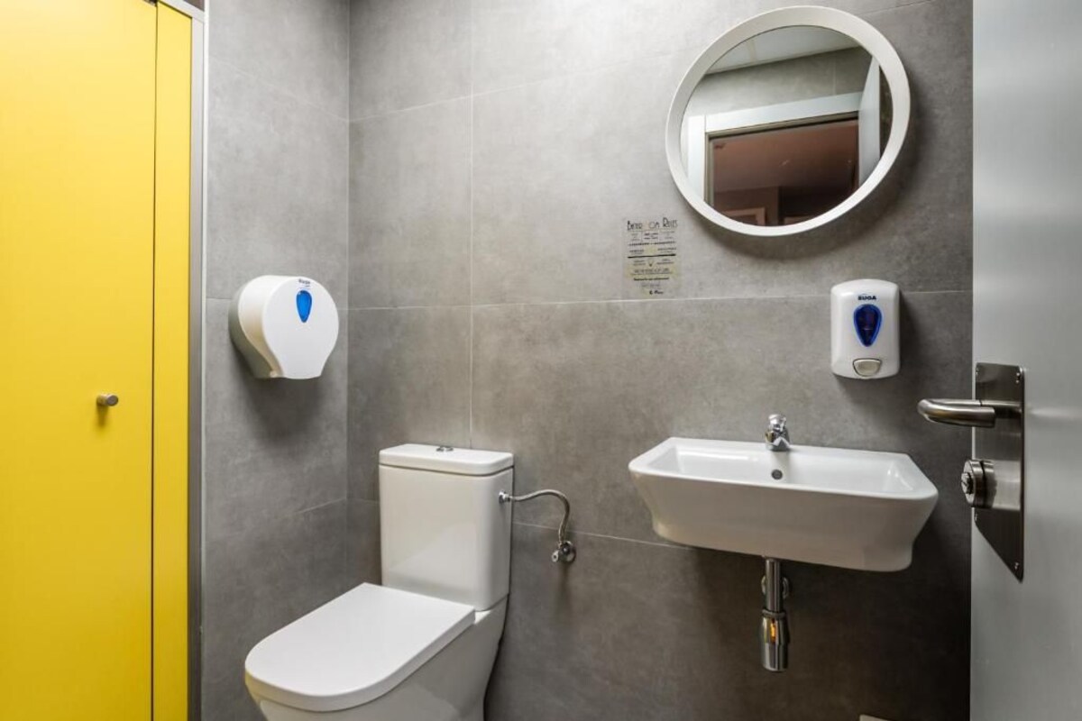 Ein Badezimmer mit Toilette, Waschbecken und Spiegel.