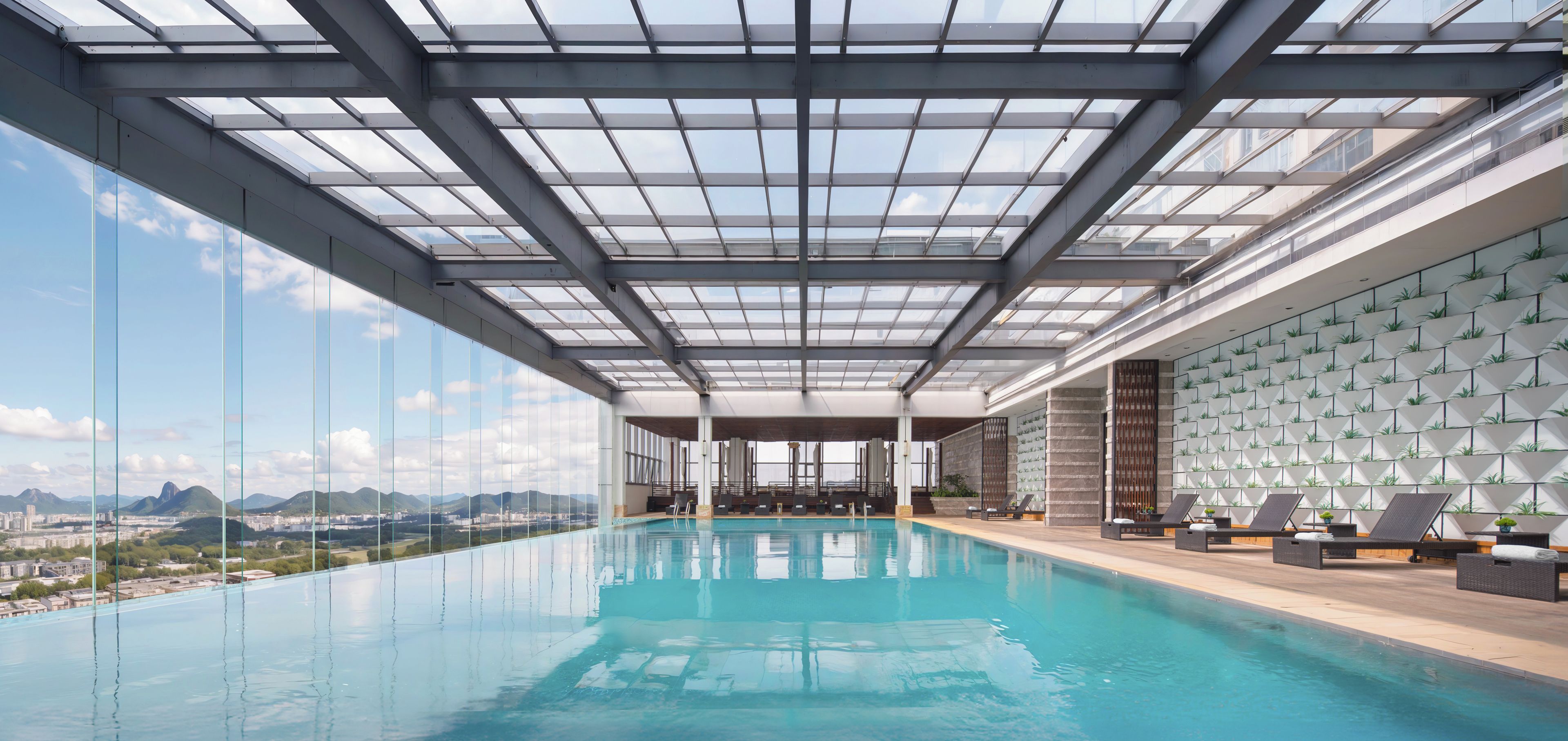 An indoor swimming pool with a glass ceiling, a view of the city, and a wall with geometric patterns.