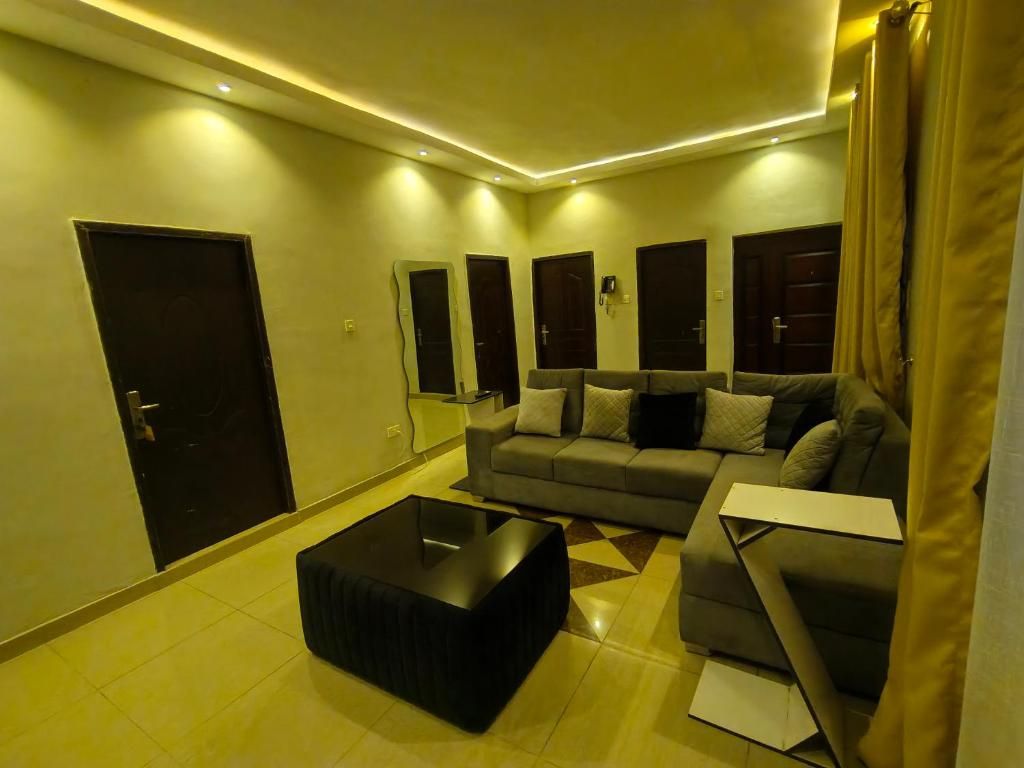 A modern living room with a sofa, a coffee table, and a door.
