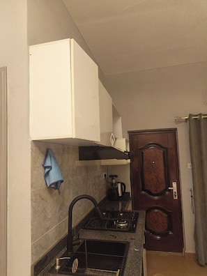 Uma cozinha com fogão, pia e armário.