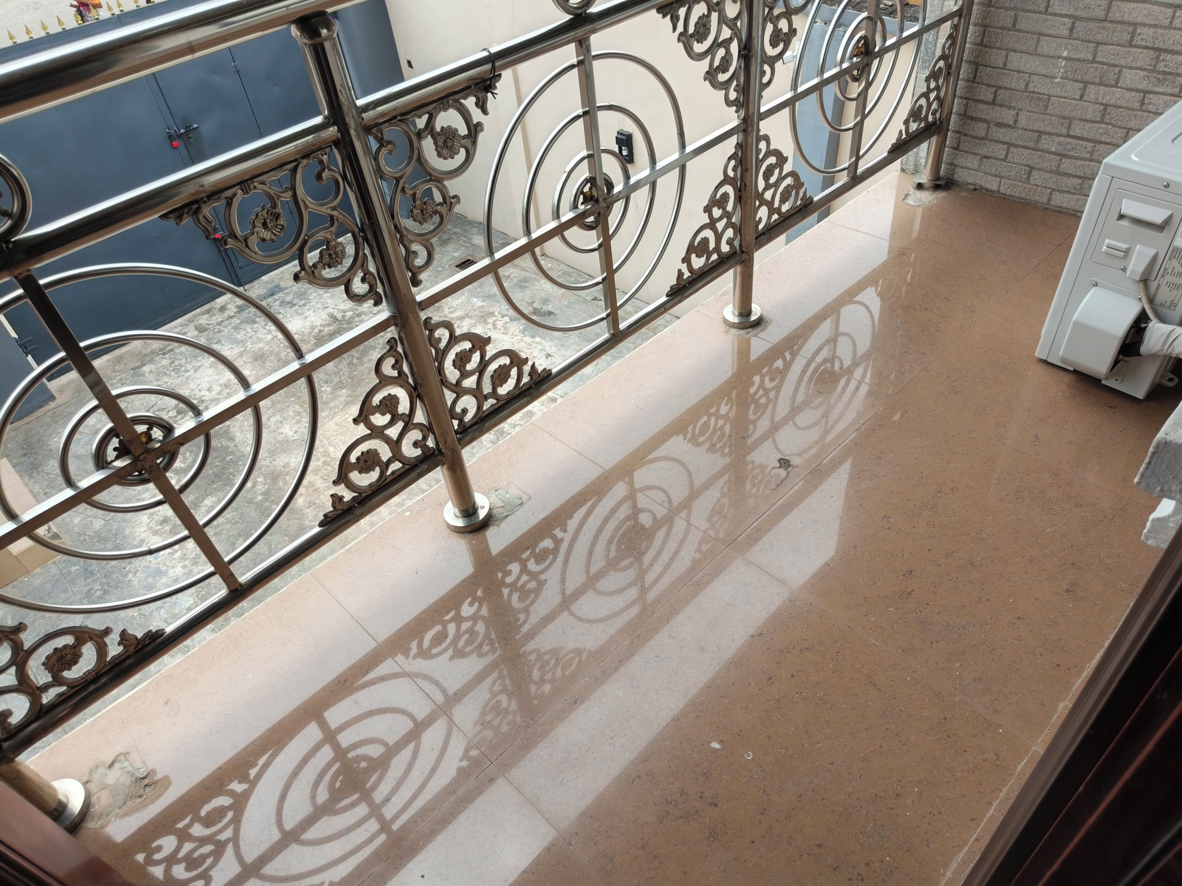 A balcony with a metal railing and a tiled floor.