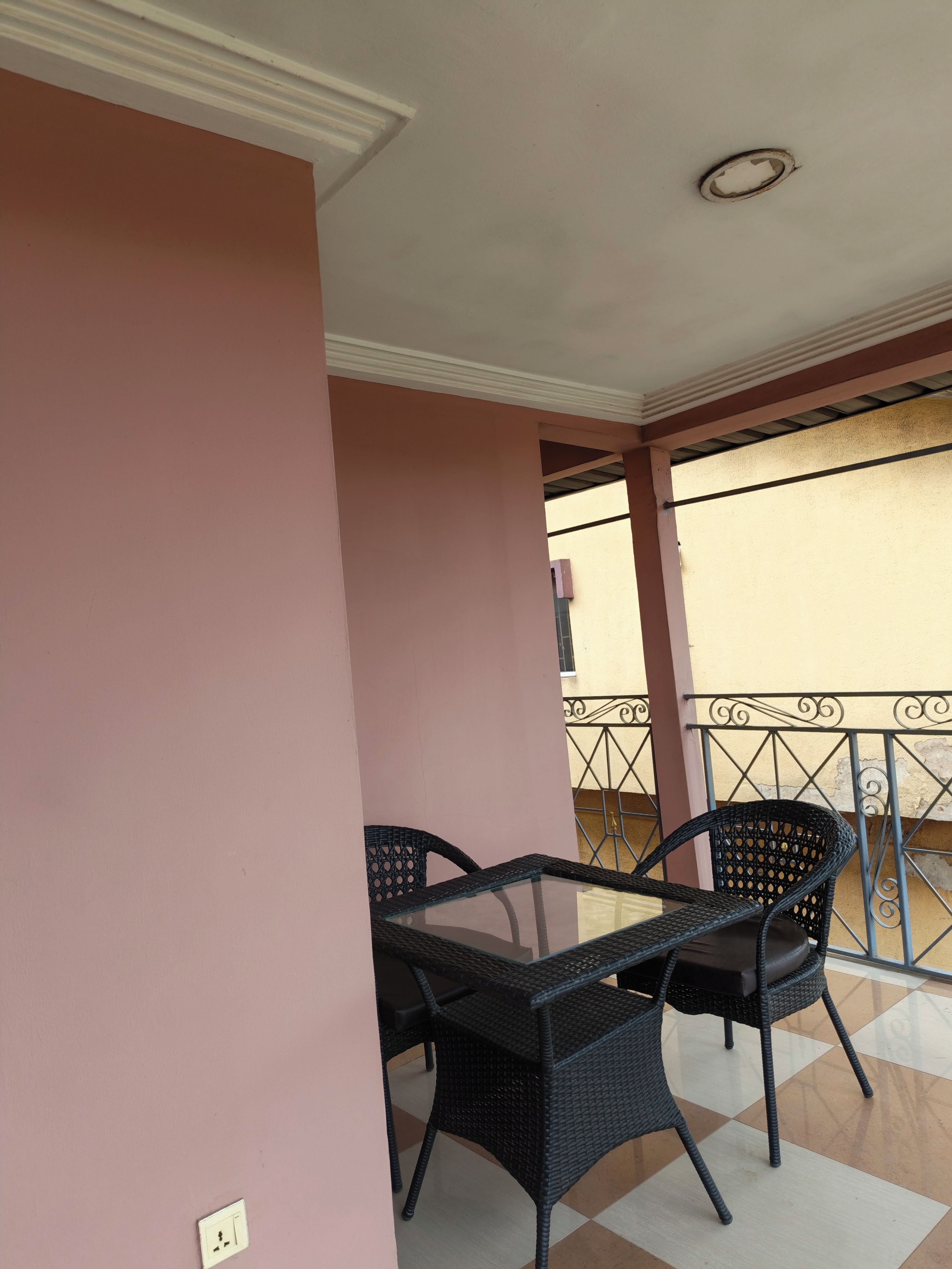 Ein Balkon mit Tisch, Stühlen, Geländer und Blick ins Freie.
