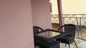 Ein Balkon mit Tisch, Stühlen, Geländer und Blick ins Freie.