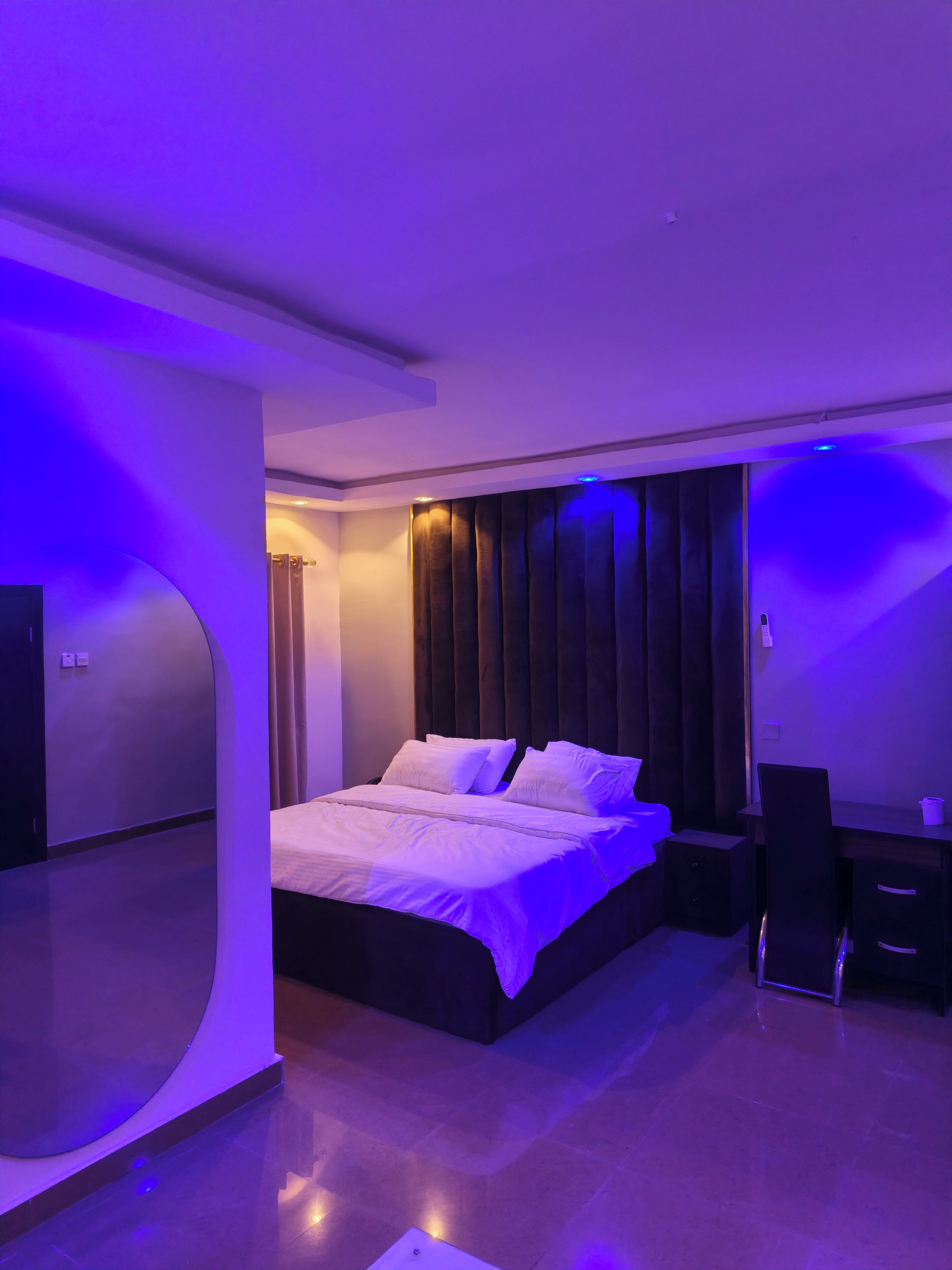 A modern bedroom with a bed, a desk, and a chair.