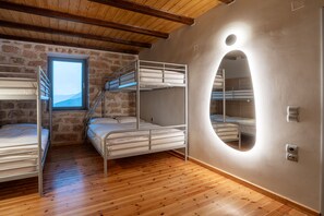 A room with bunk beds, a window, and a mirror.
