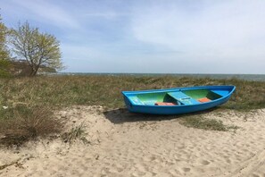 A blue boat on a sandy beach with a clear sky. - Residence Margarete 1.13 (Ostseebad Binz)