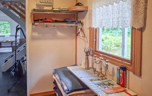 A room with a bed, a window with lace curtains, a shelf with items, and a vacuum cleaner. - Beautiful home in Degernäs with WiFi (Degernäs)