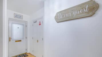 Een gang met een bord waarop staat 'Wees onze gast', een 'Niet roken'-bord en een bord met de tekst 'Dit is onze gelukkige plek'.