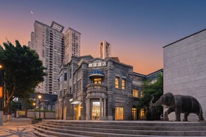 Un edificio con fachada tradicional, una escalera que lleva a la entrada y una gran escultura de animal en la parte delantera.
