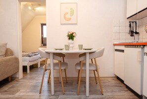 Un espai habitable reduït amb zona de menjador, petita cuina i llit.