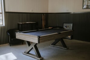 A pool table in a room with a sloped ceiling and a chair. - The Perfect Romantic Getaway: Cute Tiny House near the Grampians National Park in Dadswells Bridge, Victoria (Dadswells Bridge)