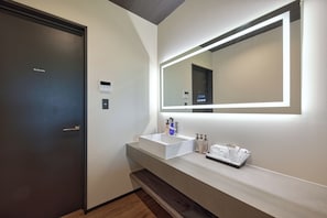 A modern bathroom with a large mirror, a white sink, and a door. - SUITE VILLA -AOI- (Takashima-shi)