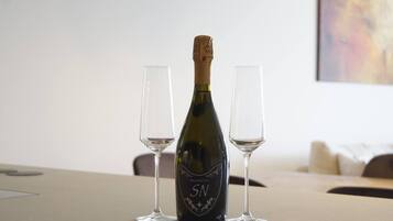 A bottle of Prosecco SN wine with two empty glasses on a table.