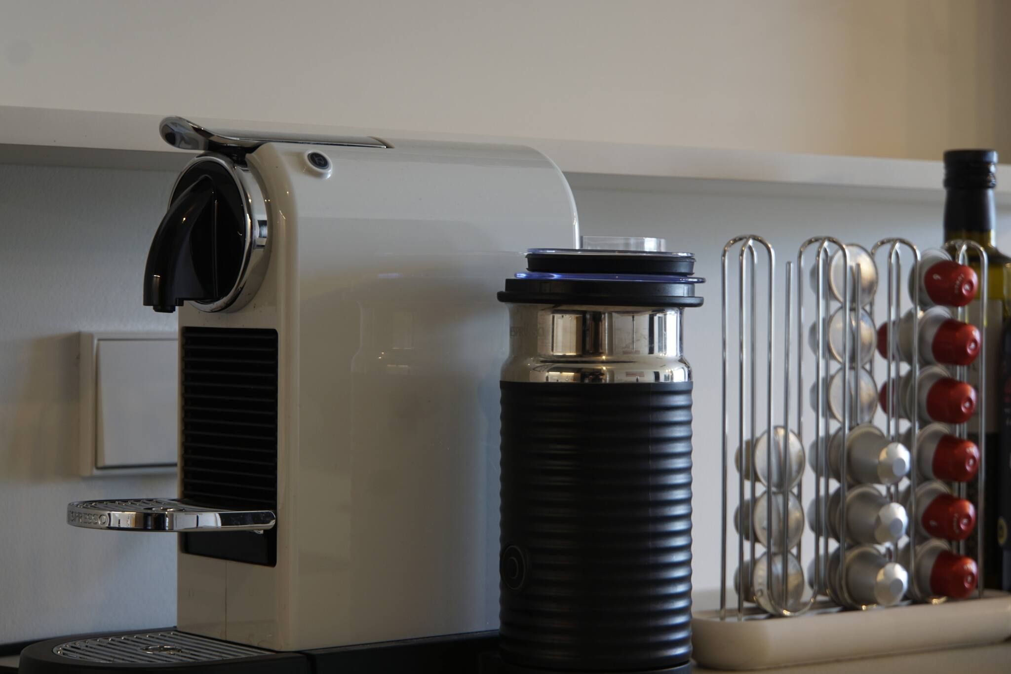 Une machine à café dotée d’un réservoir d’eau et d’un récipient en métal agrémenté d’éléments rouges et argentés.