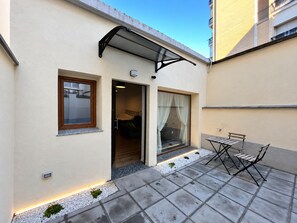 A small, single-story building with a patio area featuring a table and chairs. - DELIGHTFUL INDEPENDENT LOFT IN ALPI ARENA WITH FREE PRIVATE PARKING (Torino)