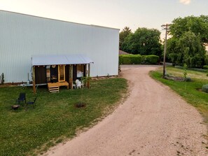A gravel path leading to a building with a covered porch and outdoor seating.