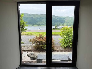 A view through a door with a stone bench and a sign reading 'GENEVE COAT CLUB' in the background.