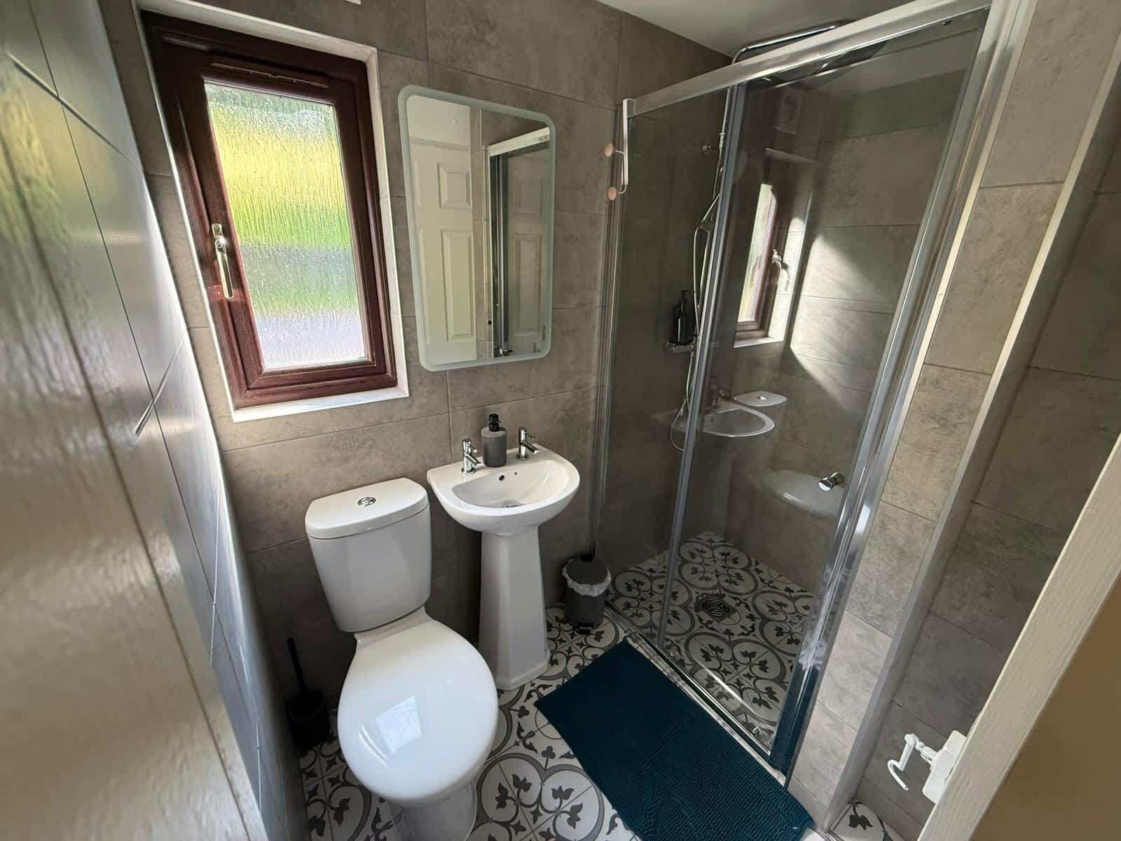 A bathroom with a toilet, sink, and glass-enclosed shower.