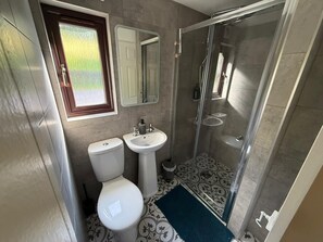 Ein Badezimmer mit Toilette, Waschbecken und einer Duschkabine.