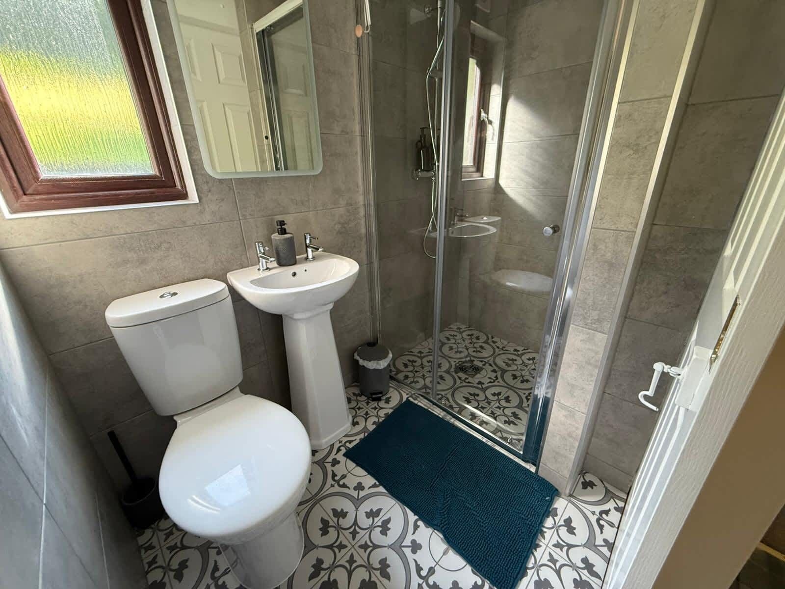A bathroom with a toilet, sink, and glass-enclosed shower.